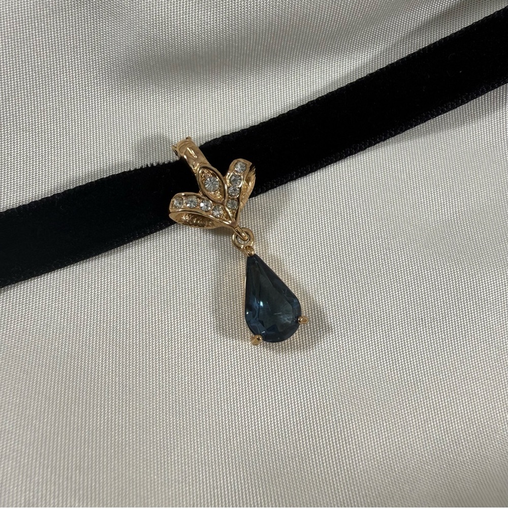 Vintage gold plated,removable Roman enhancer w/ blue crystal in teardrop design.